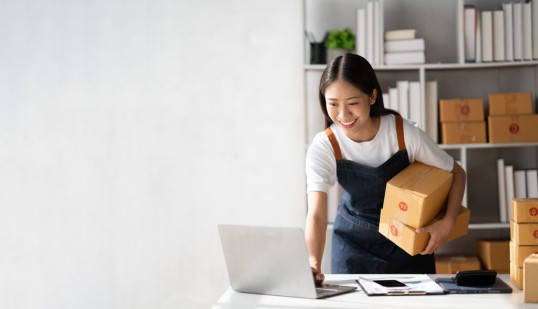 a woman is sticking a label on a parcel