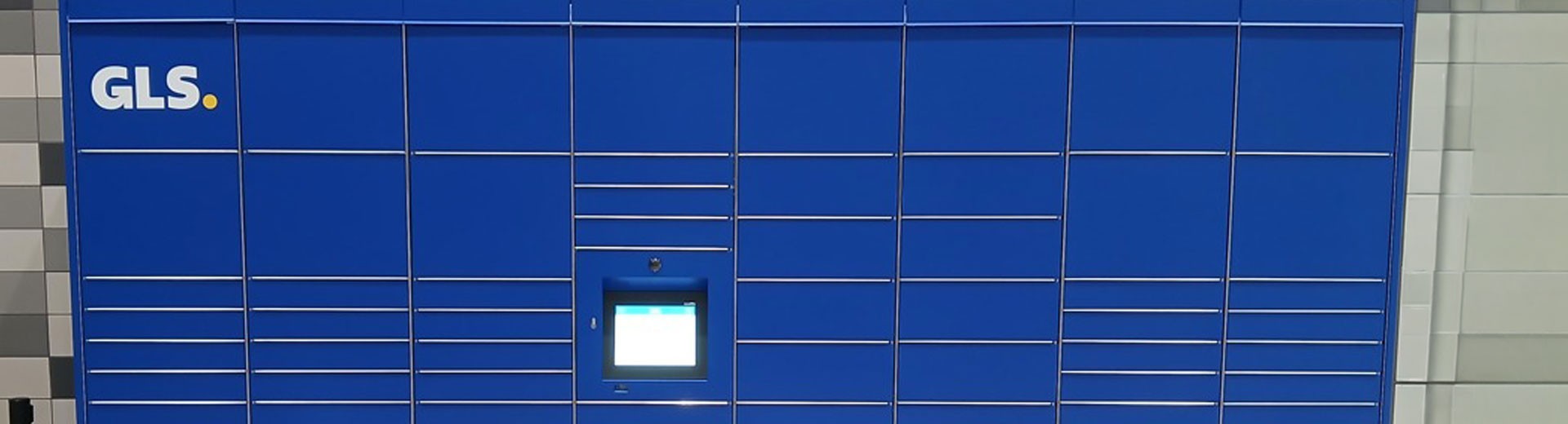Parcel Locker inteligente de GLS para recoger paquetes en un centro comercial, con taquillas automáticas azules y pantalla táctil de autoservicio.
